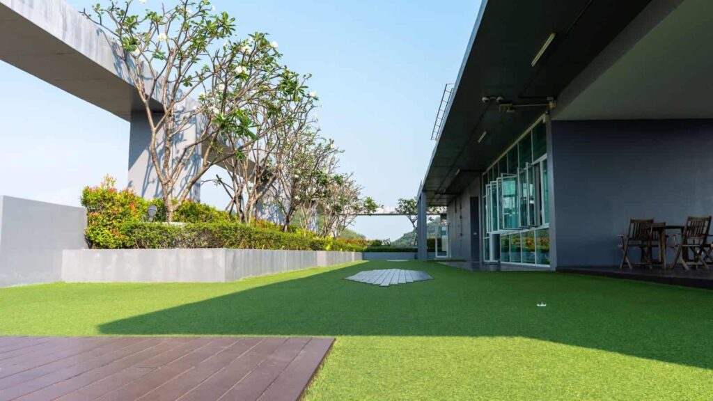 Azotea de edificio con césped artificial y jardineras