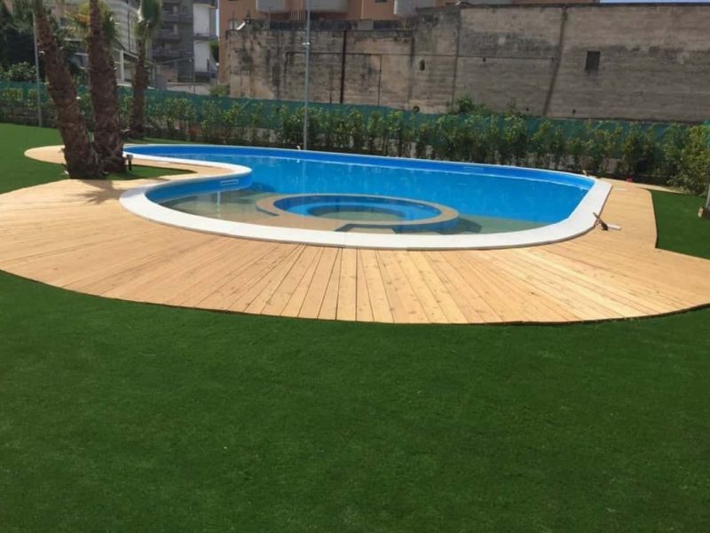 Cesped residencial piscina con tablas de madera