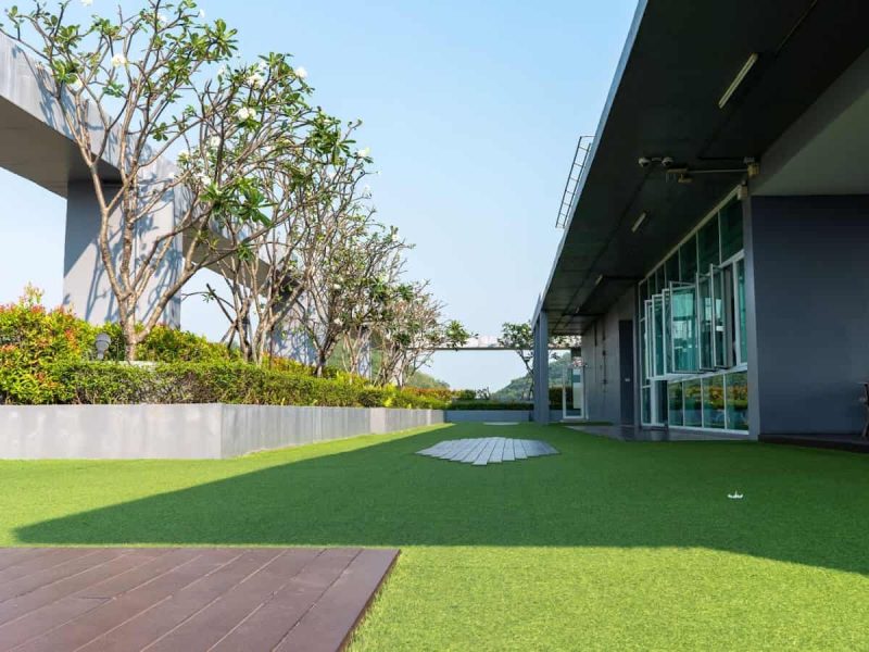 Azotea de edificio con césped artificial y jardineras