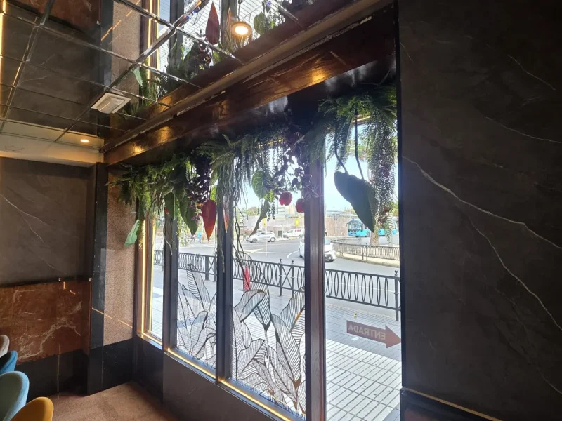 Plantas artificiales colgantes instaladas por Flor And Design en la cristalera de un restaurante