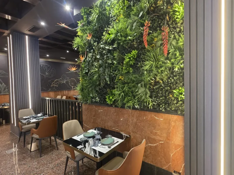 Jardín vertical artificial con aves del paraíso instalado por Flor And Design en un restaurante