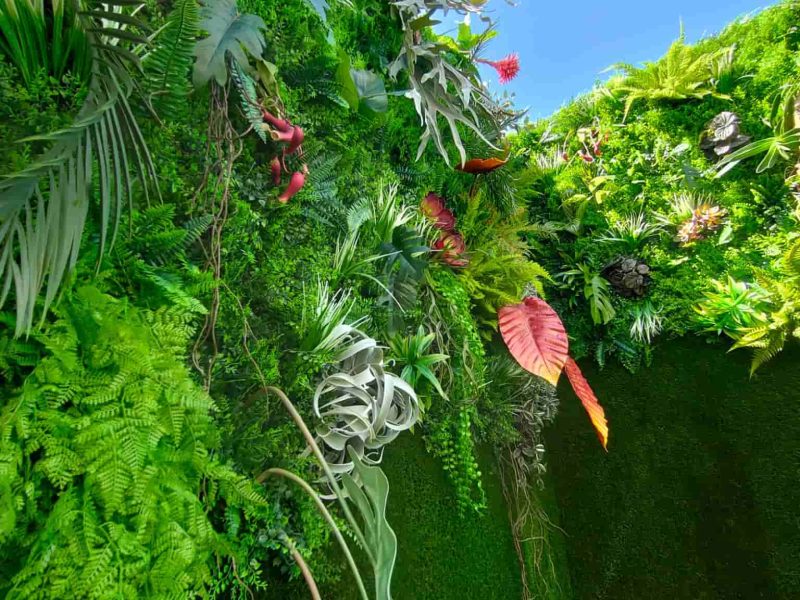 Patio con jardín vertical artificial de plantas tropicales