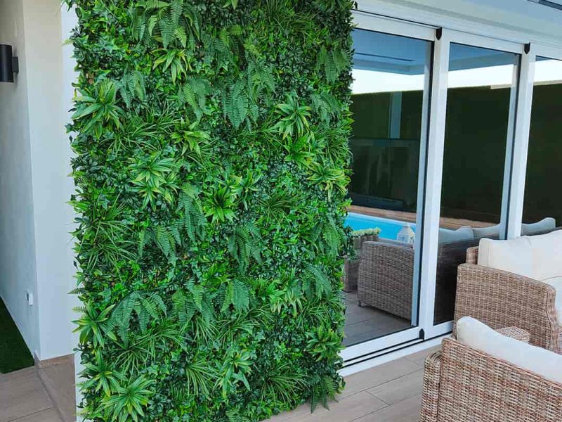 Jardín vertical artificial en un porche con césped artificial